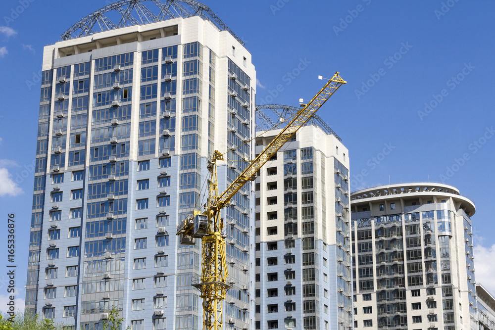 Tower crane against the background of three new high-rise buildings Tower crane against the background of three new high-rise buildings
