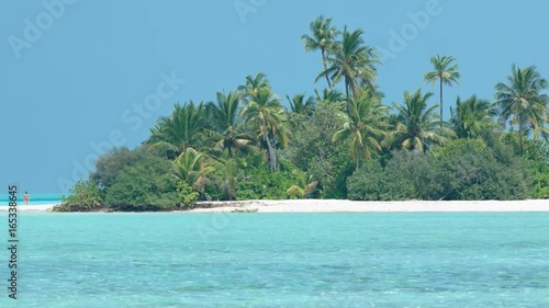 Lone Tourist Strolling on a Deserted Island near Mahaanaelhihuraa, Maldives photo