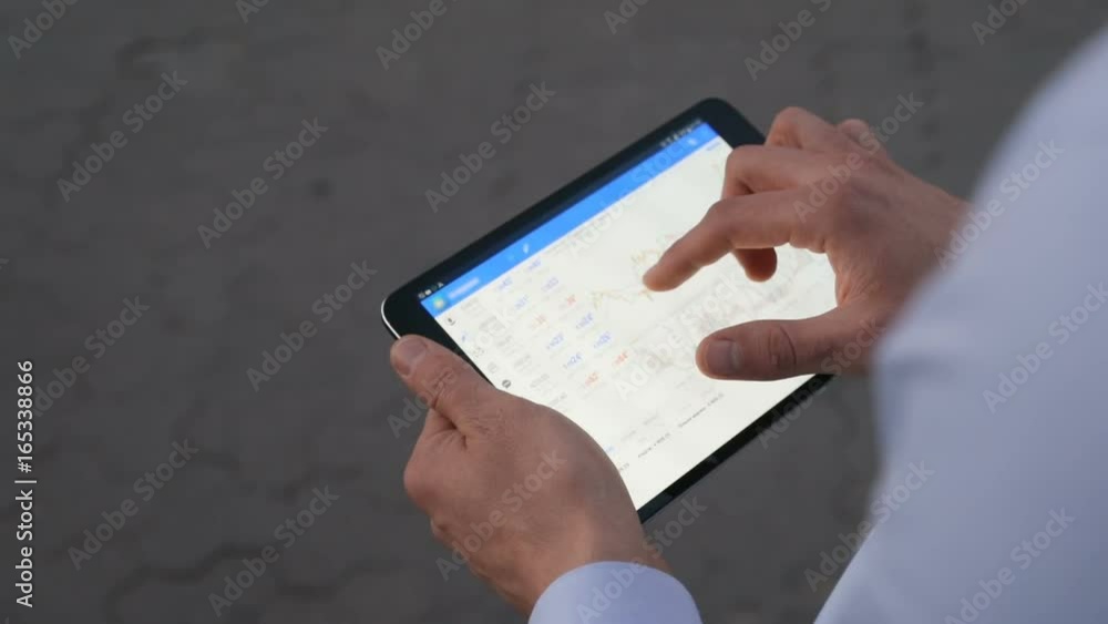 Man hands holding tablet using touch screen graphs charts working ...