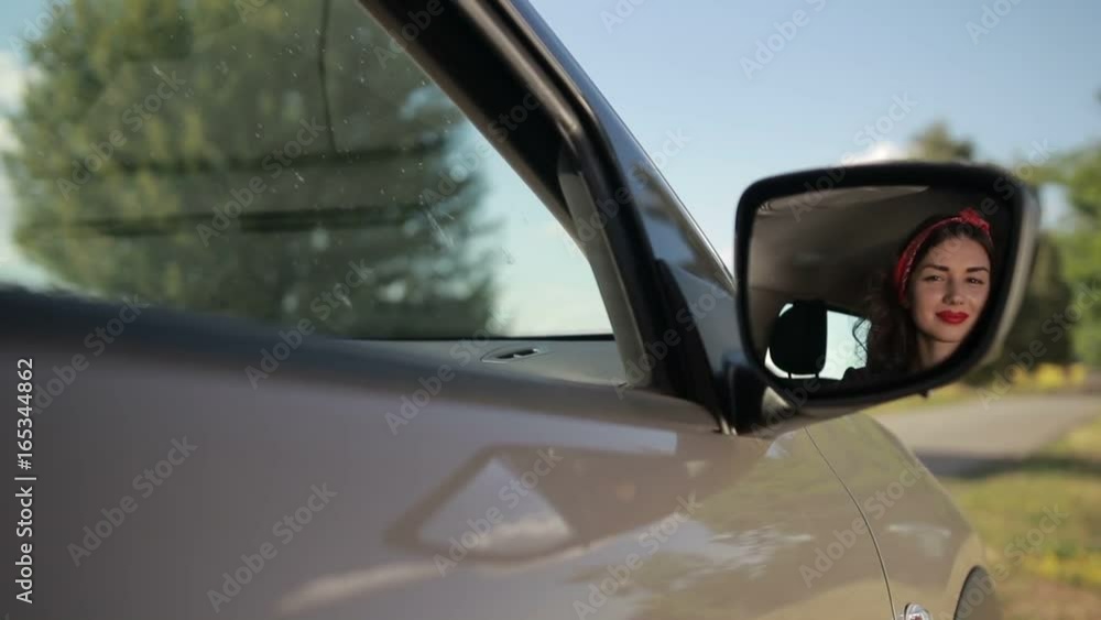 Reflection of cute girl in rearview mirror of car Reflection of cute girl in rearview mirror of car