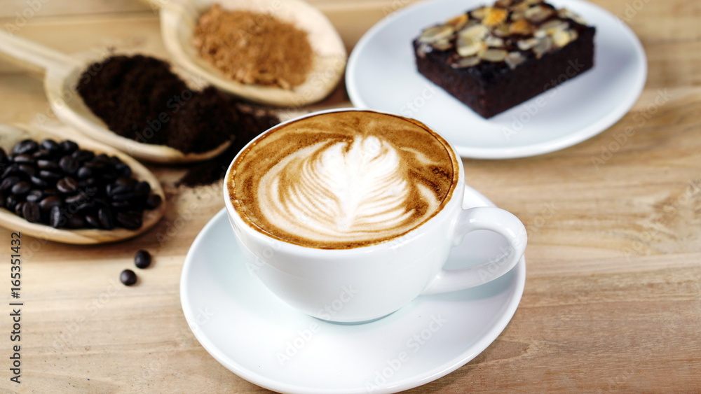 Latte art and cappuccino with Rosetta leaf and flowers made from milk on the wood table with roasting coffee beans. Beverage and breakfast or food and drink menu with hot coffee at the cafe shop. Latte art and cappuccino with Rosetta leaf and flowers made from milk on the wood table with roasting coffee beans. Beverage and breakfast or food and drink menu with hot coffee at the cafe shop.
