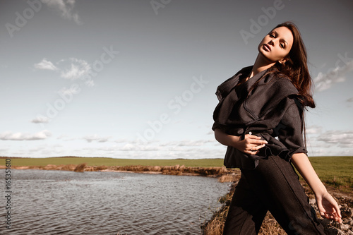 Outdoors portrait of a fashionable young brunette woman posing