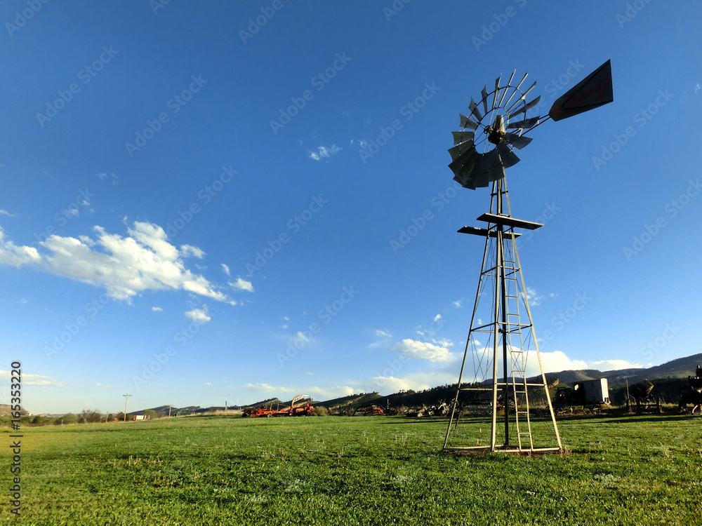Vintage antique agricultural windmill on farm grassland