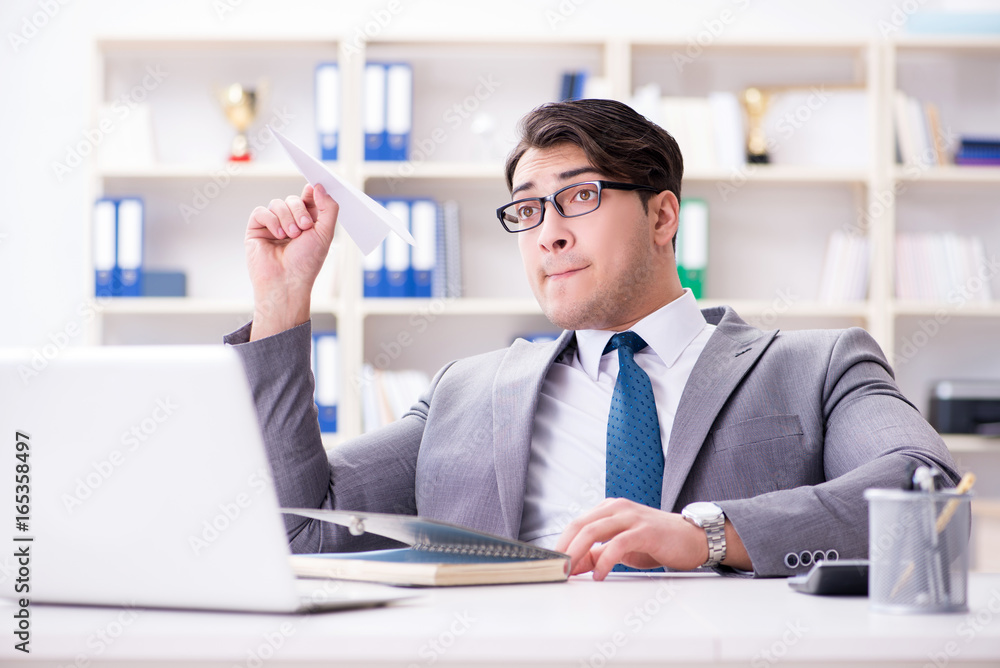 Businessman with paper airplane in office Businessman with paper airplane in office