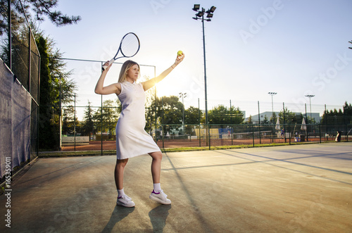Artistic beautiful image of woman tennis player preparing to serve , outdoors 