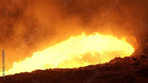 Liquid metal from blast furnace. Liquid metal pouring stream photo