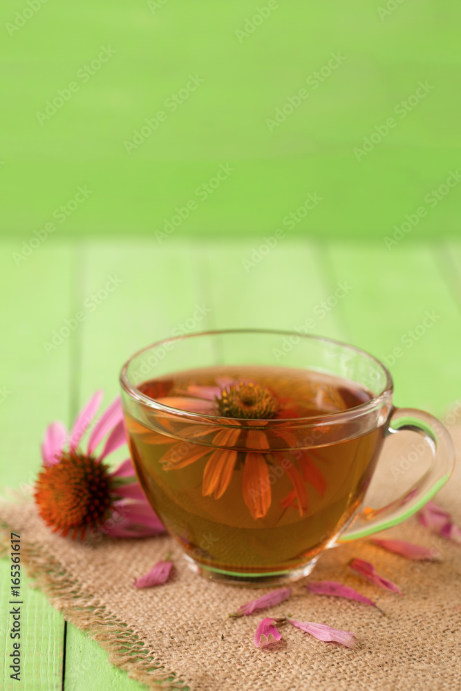 Cup of echinacea tea on green wooden table Cup of echinacea tea on green wooden table