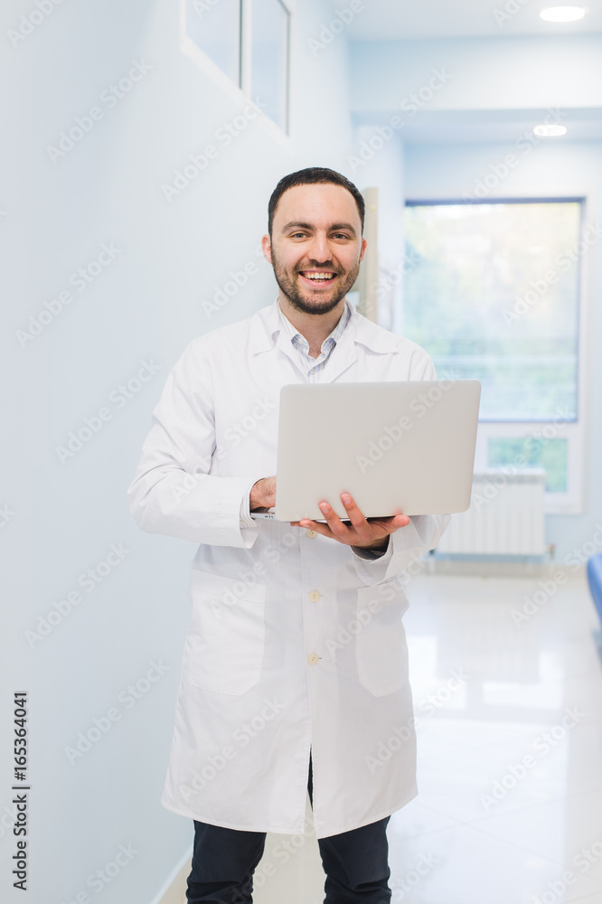 Portrait Of Doctor Holding Laptop, Indoors Portrait Of Doctor Holding Laptop, Indoors