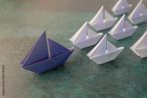 Origami paper big sailboat with small sailboats  leadership  marketing concept  social media influencers  HR recruiter  standing out concept