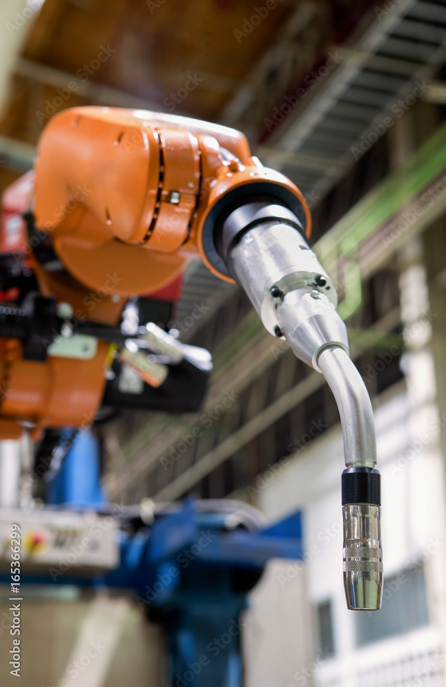 Closeup robot welding arm in factory Closeup robot welding arm in factory
