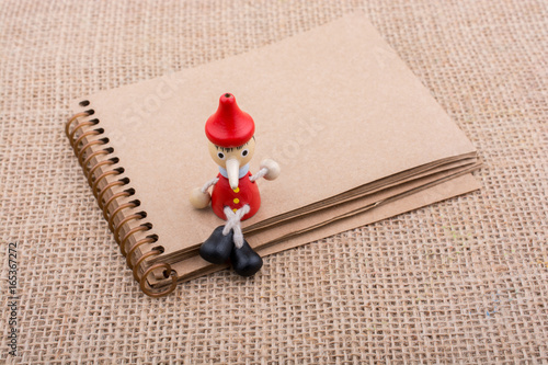 Wooden Pinocchio doll sitti...