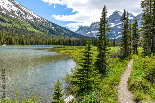 Mountain Lake Trail - A spring view of a hiking trail along Lake Josephine at the base of Mount Gould in Many Glacier region of Glacier National Park, Montana, USA. photo