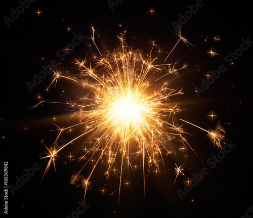 Glittering sparkler on black background