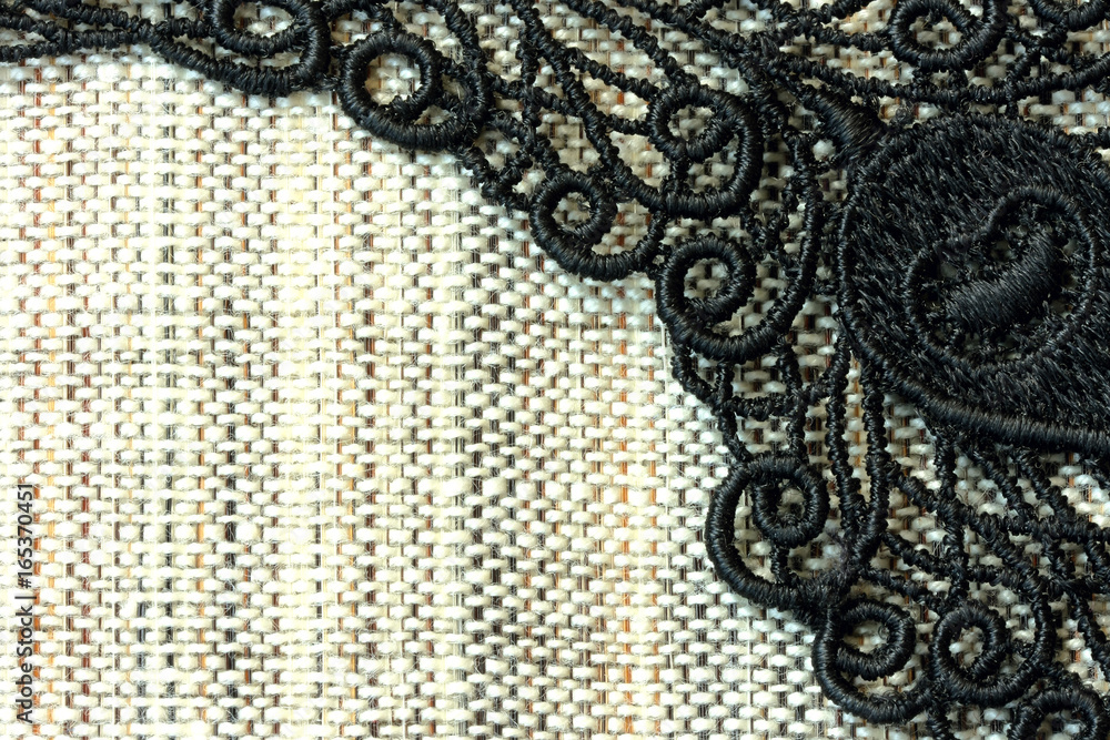 Obraz premium Detail of black lace on rough simple fabric