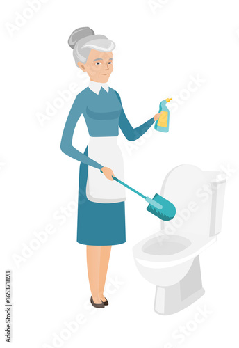 Senior caucasian cleaner cleaning toilet bowl.