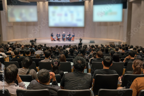 Rear view of Audience over the speakers on the stage in the conference hall or seminar meeting, business and education concept