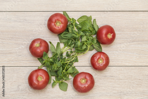 Tomatoes and basil leafs isolated on a wooden background, italian food pattern