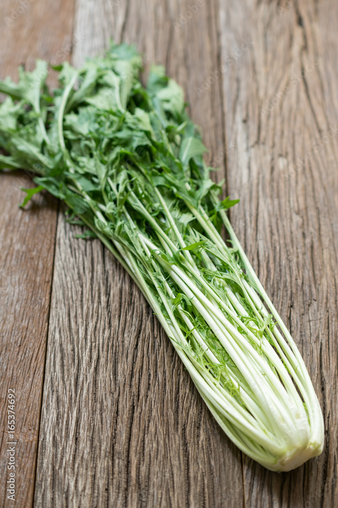 Bunch of fresh Mizuna leaves on wood background. Bunch of fresh Mizuna leaves on wood background.