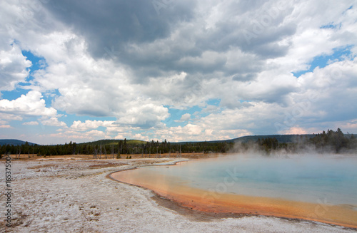 Sunset Lake under cumulus clouds in Black Sand Basin in Yellowstone National Park in Wyoming United States