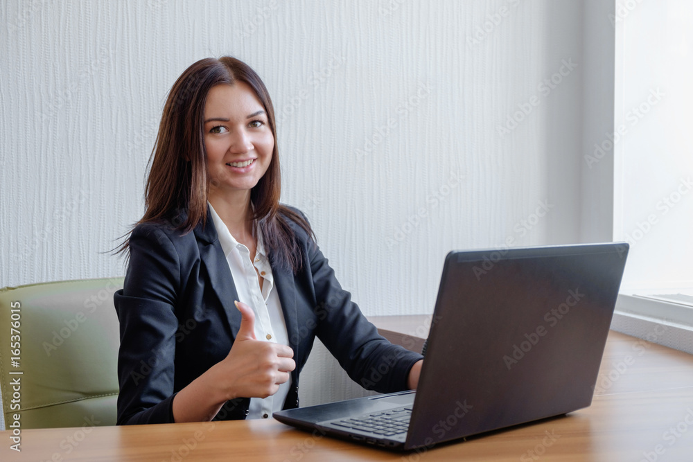 smiling business woman working on laptop and shoving thumbs up smiling business woman working on laptop and shoving thumbs up