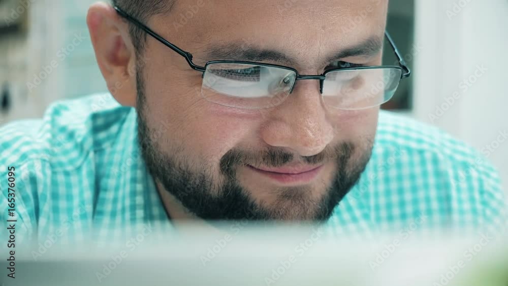Close up of young man reading his tablet in the dark. background. 4k Close up of young man reading his tablet in the dark. background. 4k
