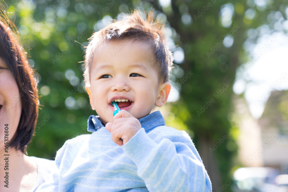 Asian baby uses toothbrush in the park, summer time Asian baby uses toothbrush in the park, summer time