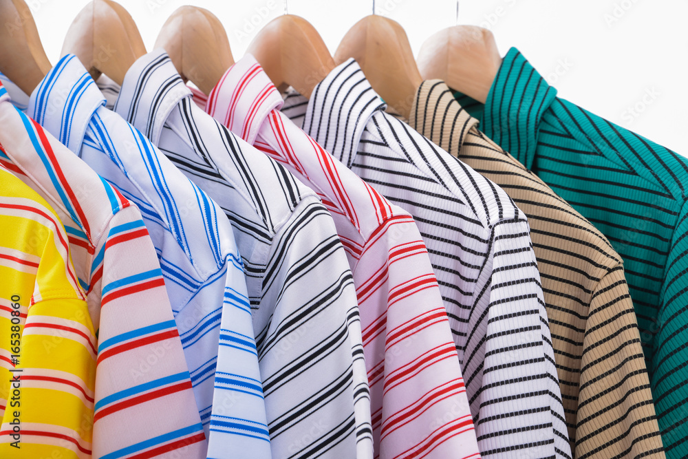 Variety of men's clothes shirts on hangers Stock Photo
