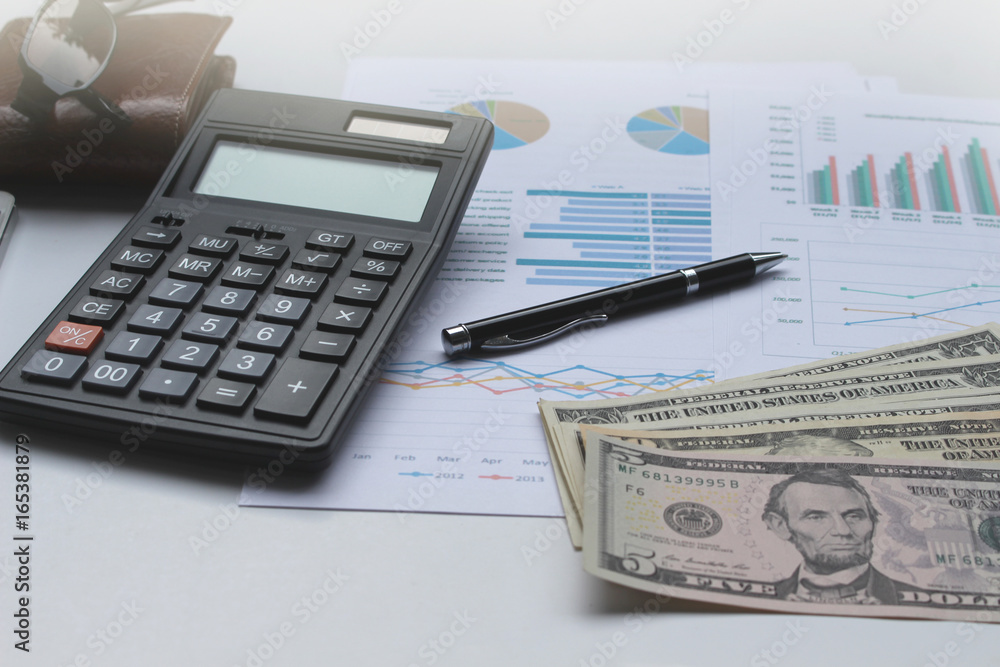 Calculator and Dollar money on the office desk investment and property for concept Calculator and Dollar money on the office desk investment and property for concept