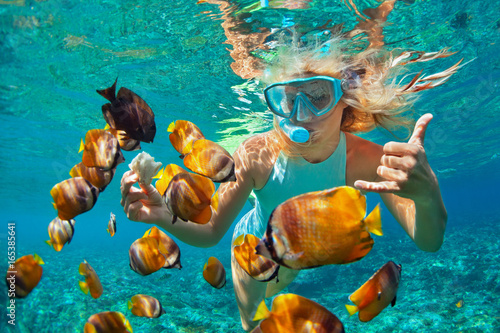 Canvas Print Happy family - girl in snorkeling mask dive underwater with tropical fishes in coral reef sea pool