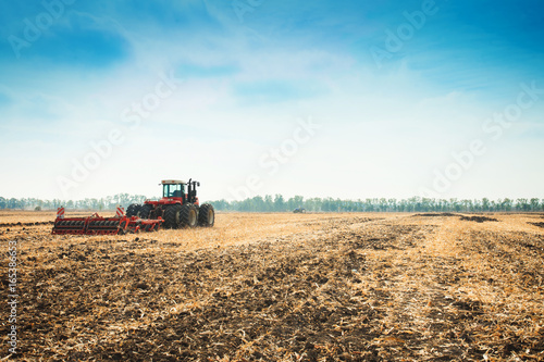 Modern tractor in the field with complex for the plowing.