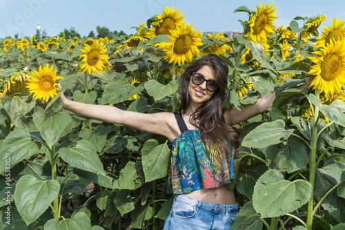 beautiful happy woman smiling in a sunflower field