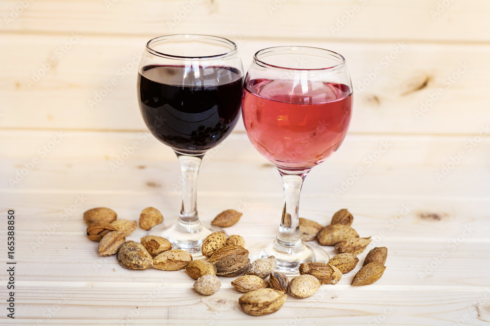 Glasses of red wine and rose with almond nuts in shell Glasses of red wine and rose with almond nuts in shell