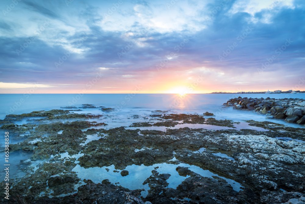 Obraz premium Tropical sunset with ocean and corals on foreground