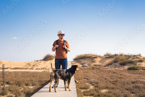 Outdoors lifestyle image of travelling man with cute dog. Tourism concept. photo