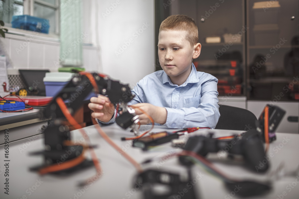Boy operating machinery at table in classroom Boy operating machinery at table in classroom