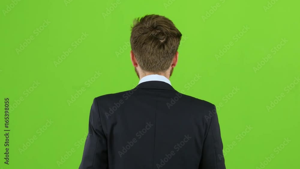 Businessman is going to a meeting and waving greetings. Green screen. Back view Businessman is going to a meeting and waving greetings. Green screen. Back view