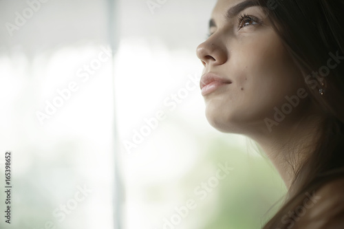 Young romantic girl by the window