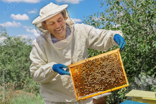 фотографія beekeeper holding a honeycomb
