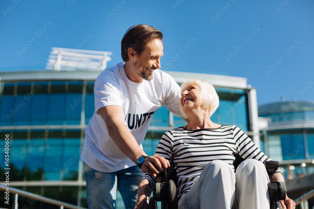 Handsome charismatic man entertaining elderly lady Handsome charismatic man entertaining elderly lady