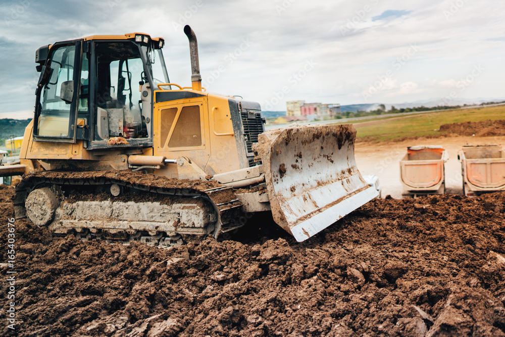highway construction site development with bulldozer moving earth, soil