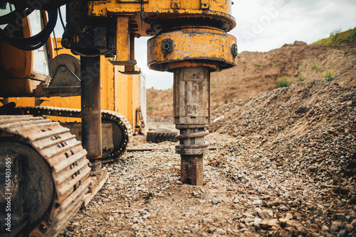 Fotografi Rotary drills, bulldozer and excavator working on Highway construction site with heavy duty machinery