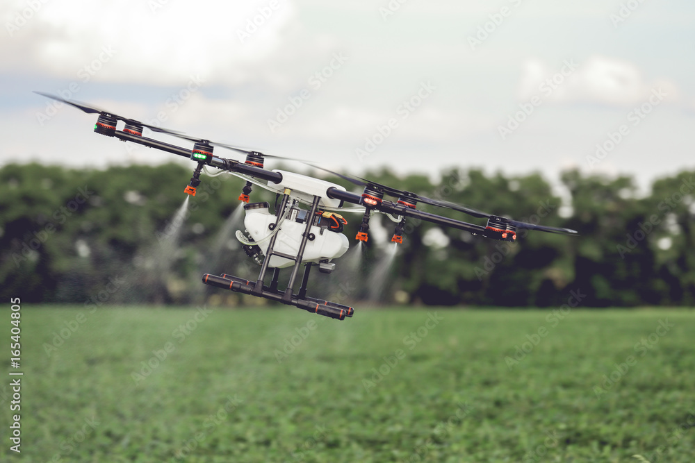 Agriculture drone fly to sprayed fertilizer on the rice fields. Industrial agriculture and smart farming Agriculture drone fly to sprayed fertilizer on the rice fields. Industrial agriculture and smart farming