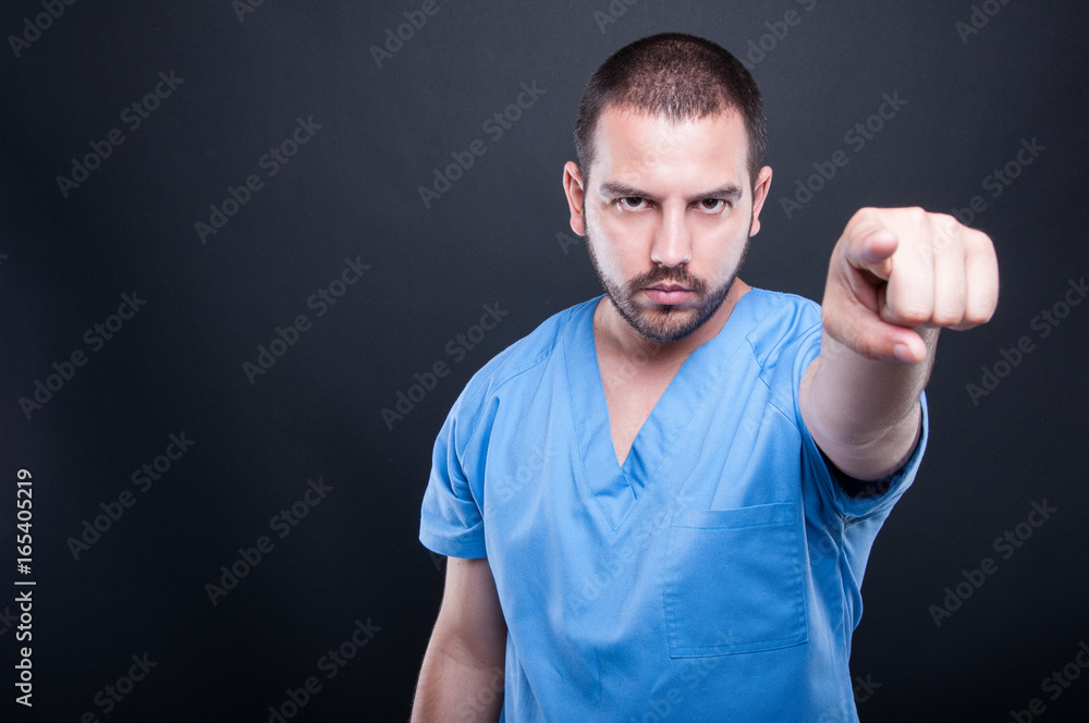 Male medical nurse pointing camera being serious Male medical nurse pointing camera being serious