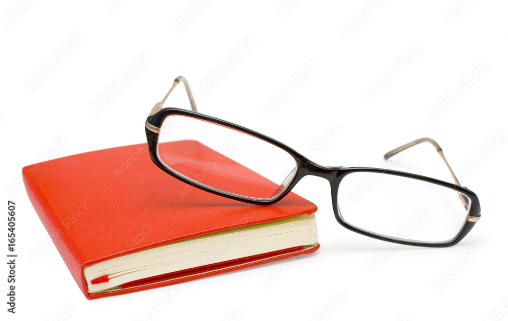 Red closed notepad and glasses isolated on white Red closed notepad and glasses isolated on white