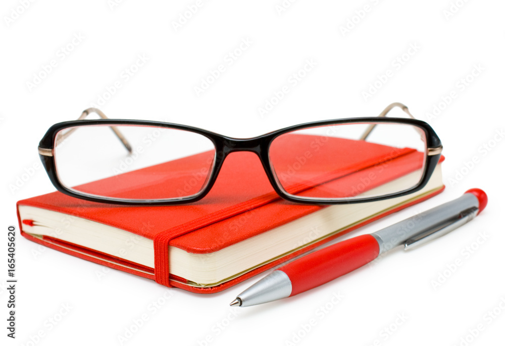 Red closed notepad, glasses and pen isolated on white Red closed notepad, glasses and pen isolated on white