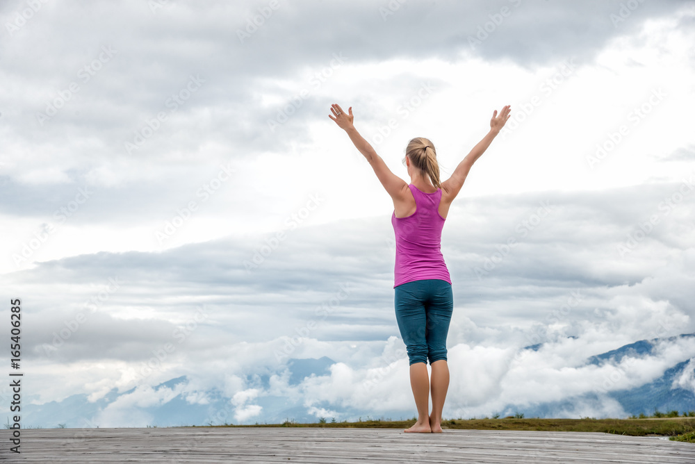 young woman meditate on top of the mountain young woman meditate on top of the mountain