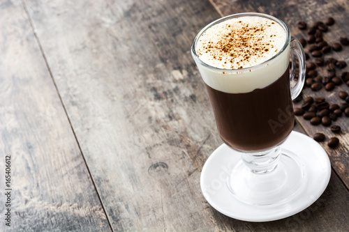 Irish coffee in glass on wooden table 