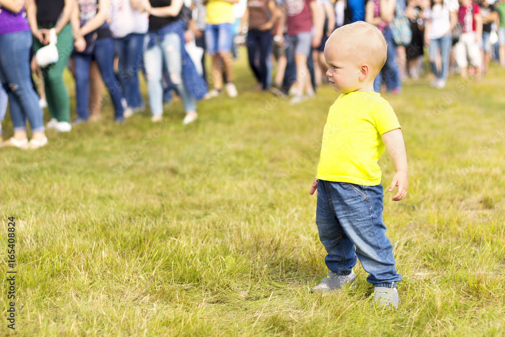 Cute toddler looks at the crowd on a music festival