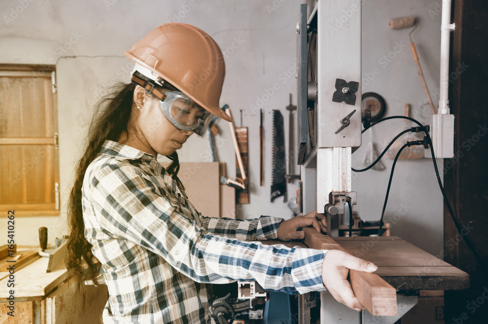 Asian pretty female carpenter Using Electric Sander for wood Asian pretty female carpenter Using Electric Sander for wood