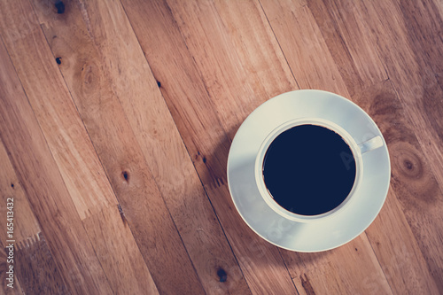 Coffee cup on wooden table (top view) - vintage style effect